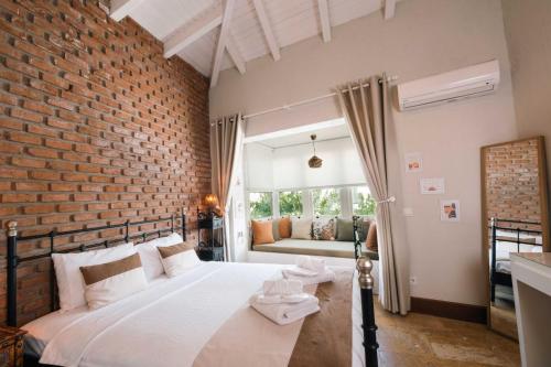 a bedroom with a large bed with a brick wall at Mono Lıfe Alaçatı in Alaçatı