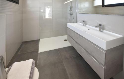 La salle de bains blanche est pourvue d'un lavabo et de toilettes. dans l'établissement Nice Home In Colonzelle With Wifi, à Colonzelle