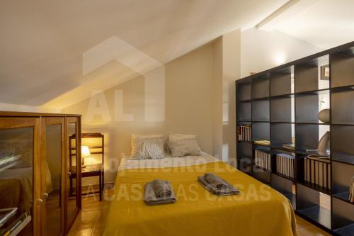 エリセイラにあるMarquinhos do Mar by AcasaDasCasasのベッドルーム(黄色のベッド1台、棚付)