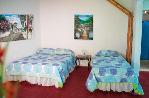 1 dormitorio con 2 camas y un cuadro en la pared en Finca Hotel San Cristobal, en Armenia