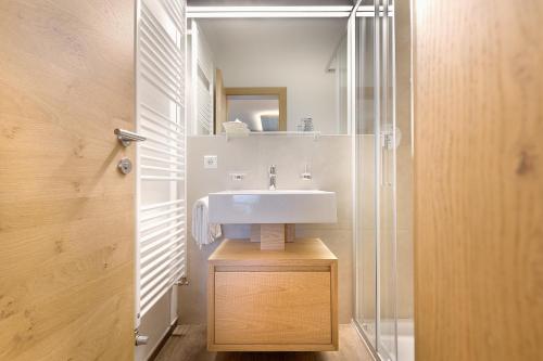 a bathroom with a sink and a shower at Hotel Krondlhof in Brunico