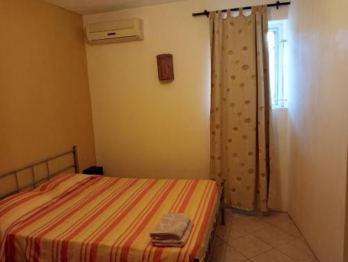 a small bedroom with a bed and a window at One bedroom appartement at Pereybere Grand Baie 350 m away from the beach with enclosed garden and wifi in Pereybere