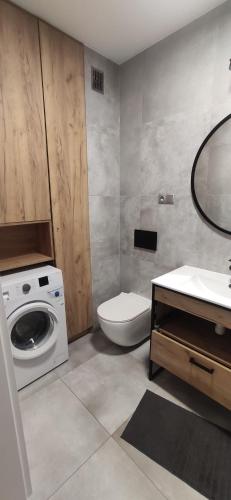 een badkamer met een wastafel en een wasmachine bij Laurowa in Tyczyn