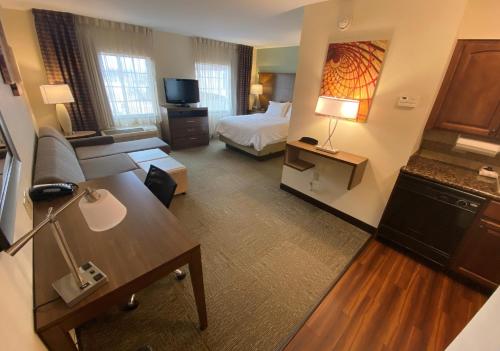 a hotel room with a bed and a living room at Staybridge Suites Great Falls by IHG in Great Falls