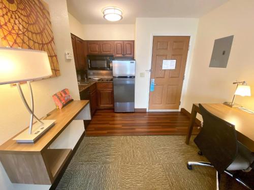 a room with a kitchen with a desk and a refrigerator at Staybridge Suites Great Falls by IHG in Great Falls