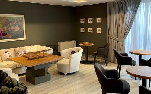 a waiting room with a couch and chairs and tables at Hotel Alfieri in Sirmione
