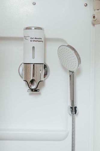 une douche avec pommeau de douche dans une salle de bain dans l'établissement Lisboa F3 Centre-ville Clermont-Fd C, à Clermont-Ferrand