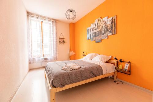 a bedroom with orange walls and a bed in it at Lisboa F3 Centre-ville Clermont-Fd C in Clermont-Ferrand
