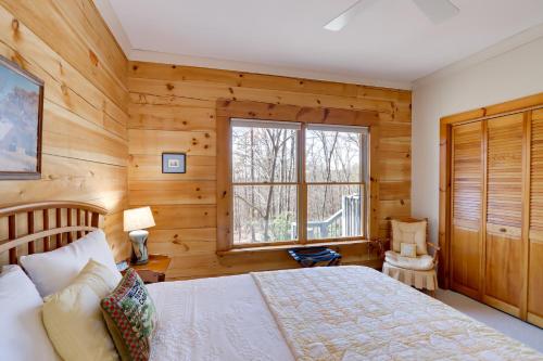 1 dormitorio con paredes de madera, 1 cama y ventana en Family-Friendly Jasper Cabin with Deck!, en Jasper