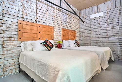 two beds in a room with wooden walls at Laredo Vacation Rental Near Tourist Attractions! in Laredo