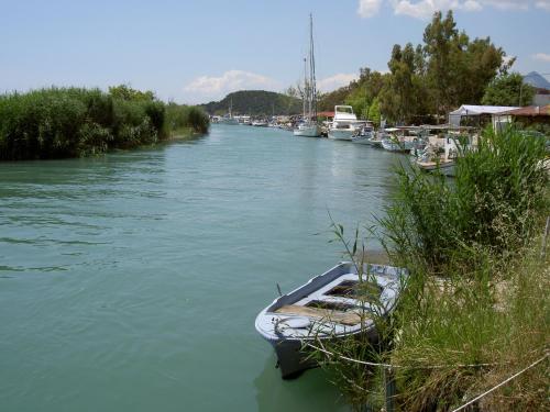 a boat is docked on a river with other boats at Hotel Glaros in Ammoudia