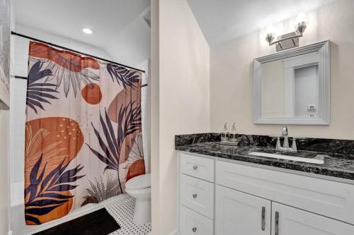 baño con lavabo y cortina de ducha en The Victorian - elegant 3BR home near Overton, en Memphis