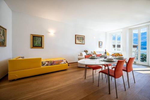 sala de estar con sofá amarillo y mesa en The View Apartment, en Domaso