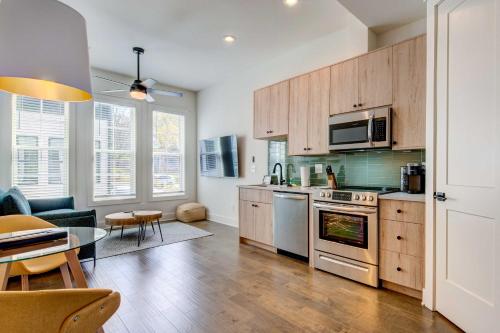 a kitchen with stainless steel appliances and a table at Modern ATL Getaway Less Than 3 Mi to Mercedes-Benz Stadium in Atlanta