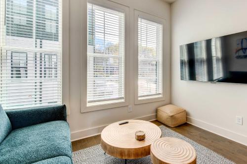 a living room with a couch and a table and windows at Modern ATL Getaway Less Than 3 Mi to Mercedes-Benz Stadium in Atlanta