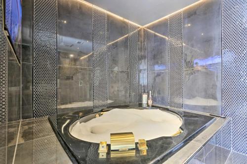 a bathroom with a tub with a bench in it at Carpathia West Estate - 7-Bedroom Villa! in Hewitt