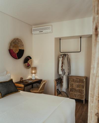 a bedroom with a bed and a table and a desk at AlmaLusa Comporta in Comporta
