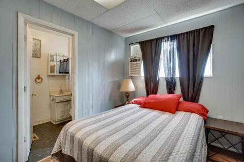 Schlafzimmer mit einem Bett mit roten Kissen und einem Fenster in der Unterkunft Pet-Friendly Vacation Rental Near Boyd Lake! in Loveland