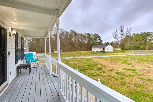 a porch of a white house with a blue chair at Richmond Home with Pool, 5 Mi to Downtown! in Richmond