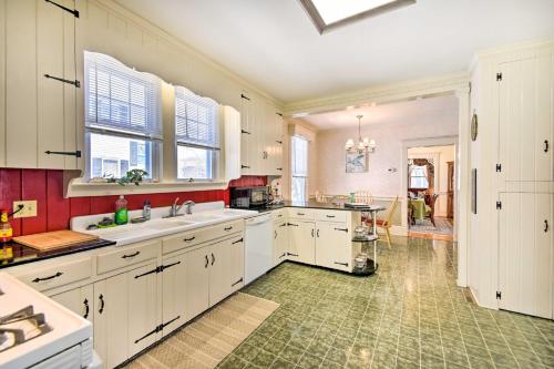 a kitchen with white cabinets and a green tile floor at Edenton Vacation Rental with Patio Walk Downtown in Edenton