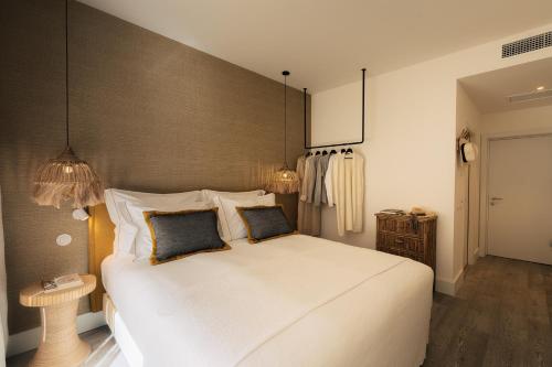 a bedroom with a large white bed with two pillows at AlmaLusa Comporta in Comporta