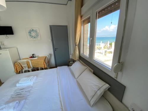 a bedroom with a bed and a large window at Sunset view Rooms in Agia Triada