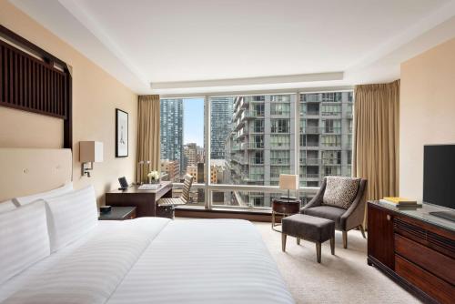a hotel room with a bed and a large window at Shangri-La Toronto in Toronto