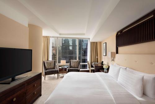 a hotel room with a bed and a flat screen tv at Shangri-La Toronto in Toronto