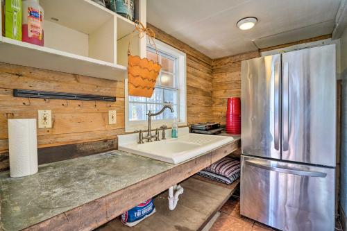 a kitchen with a sink and a refrigerator at Guadalupe River Cottage with Direct Lake Access! in Seguin