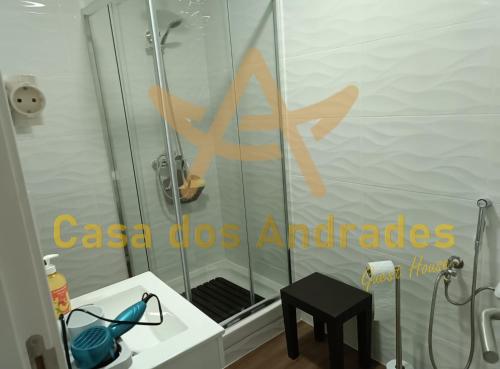 y baño con ducha con puerta de cristal y taburete. en Casa dos Andrades, en Belmonte