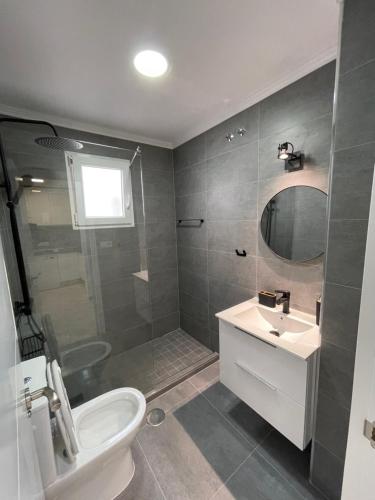 Un baño con lavabo, inodoro y espejo. en Sol y Playa Costa Blanca, en Torrevieja