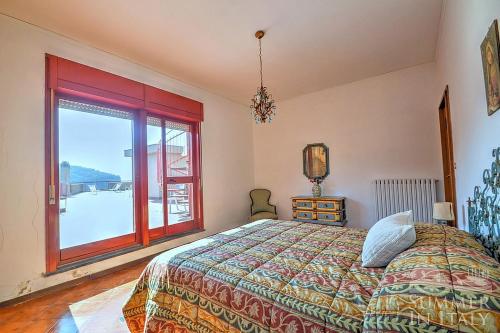 ein Schlafzimmer mit einem Bett und einem großen Fenster in der Unterkunft Casa Paradiso in Vico Equense