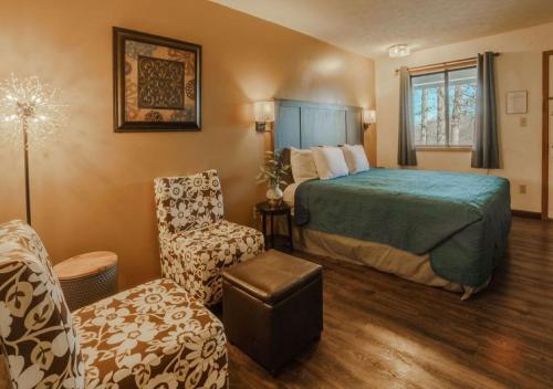 Pokój hotelowy z łóżkiem i krzesłem w obiekcie Shady Acre Inn and Suites w mieście Branson West
