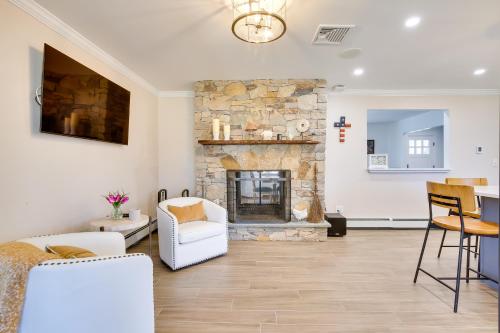 a living room with a stone fireplace and white furniture at Lovely Highland Home with Pool and Hot Tub! in Highland