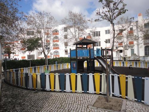 a playground in a city with a fence at Original Apartments in Albufeira
