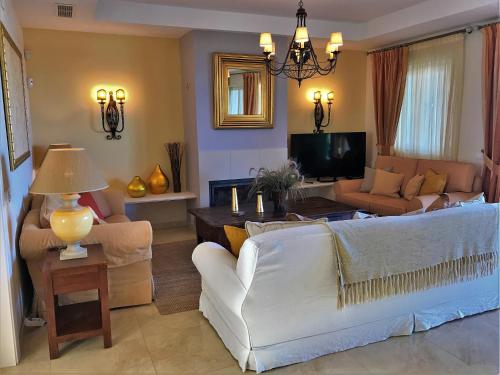 sala de estar con sofá blanco y TV en Villa PRINCESA KRISTINA, en Castillo de Sabinillas