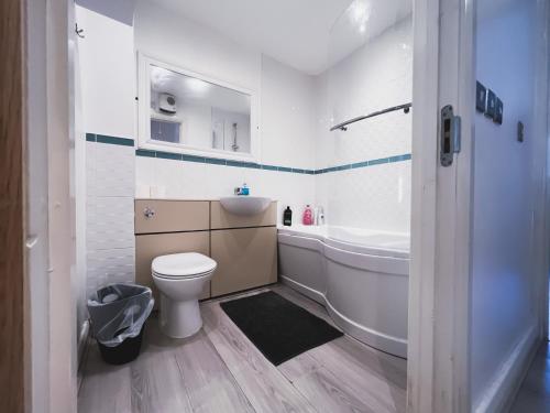 y baño con aseo, bañera y lavamanos. en Spacious 2 Bed Flat, Free Parking, Close to town, en Mánchester