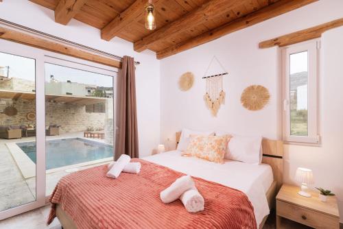 1 dormitorio con cama y piscina en Villa Pagona, en Pitsidia