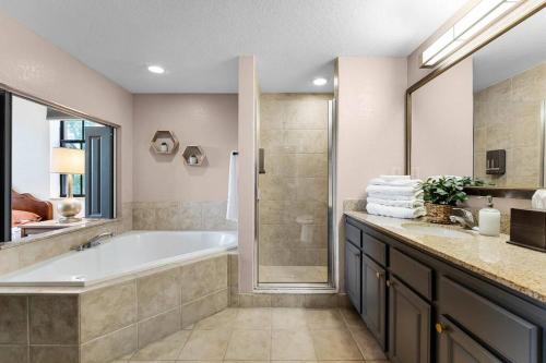 a large bathroom with a tub and a shower at Designer Corner Suite 3br/2ba - Disney, Universal, Convention Center & SeaWorld in Orlando