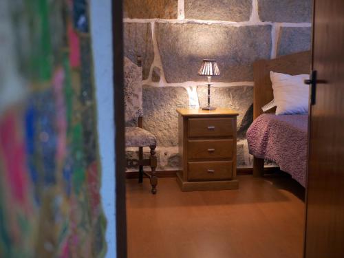 Casa do Abeto في Carvalhosa: غرفة نوم بسرير ومصباح على موقف ليلي