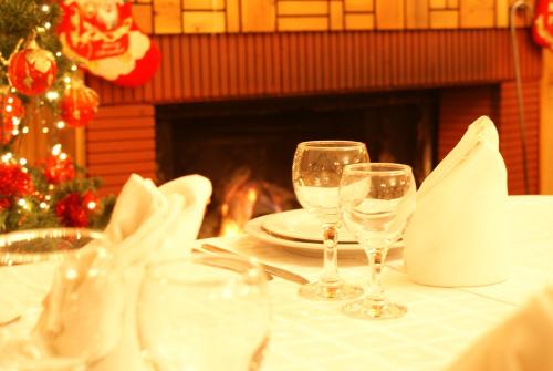 a table with two wine glasses on a table with a fireplace at Margaret's Island Hotel in Naousa Imathias