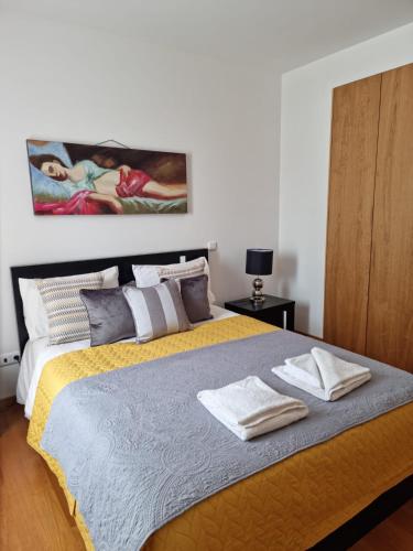 a bedroom with a large bed with two towels on it at Casa Silvana in Caniço