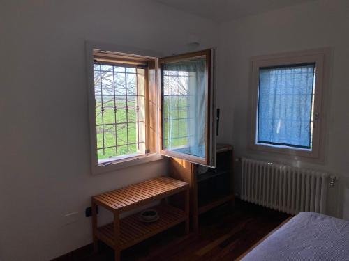 ein Schlafzimmer mit zwei Fenstern und einer Bank davor in der Unterkunft Casa di Campagna, Erbosa 2 