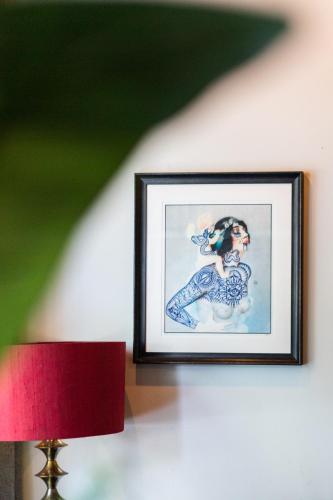 a picture of a woman on a wall with a red lamp at Weber Hotel in Amsterdam