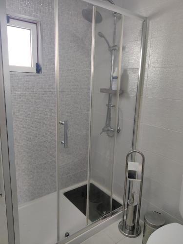 a shower with a glass door in a bathroom at Riviera Beach B in Praia da Vitória