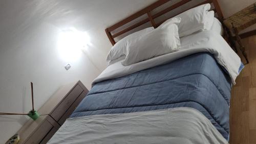 a large bed with blue sheets and white pillows at Apulia lux in Taranto