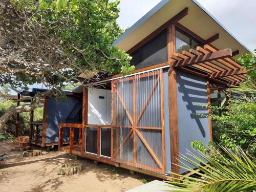 Casa pequeña con puerta y ventanas de madera en Ponta Membene, en Machavene