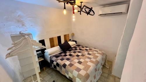 a small room with a bed and a chandelier at Casa Casco Historico in Frigiliana