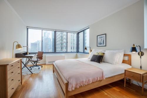 Ένα ή περισσότερα κρεβάτια σε δωμάτιο στο Midtown 2BR w Pool Gym Parking nr Broadway NYC-381