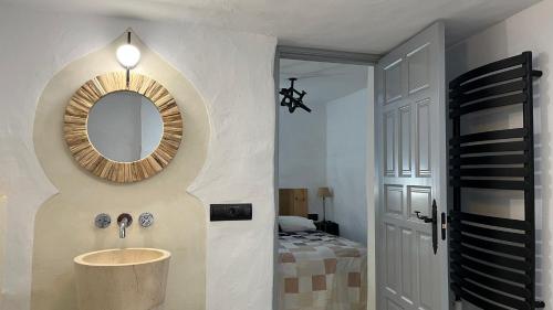 uma casa de banho com um lavatório e um espelho na parede em Casa Casco Historico em Frigiliana